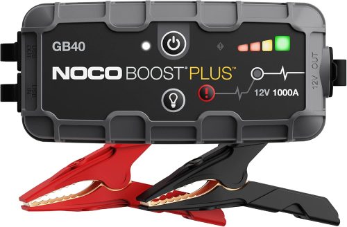 NOCO Boost GB40 portable jump starter beside a car battery in a garage