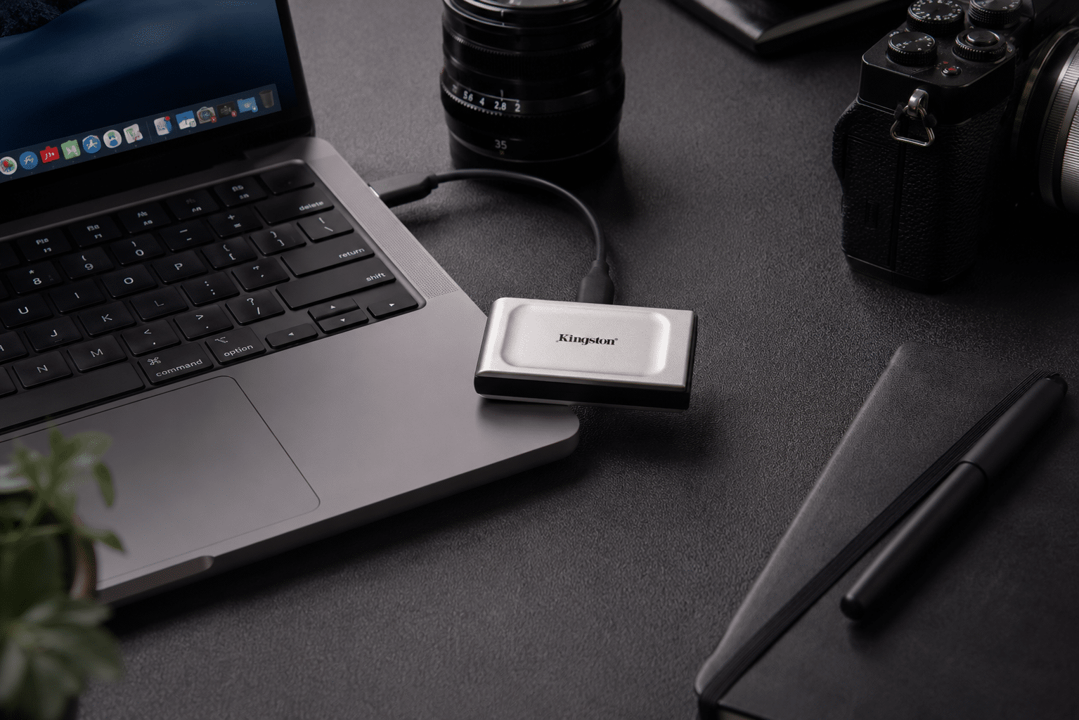 Kingston XS2000 portable SSD beside a laptop and creator workspace