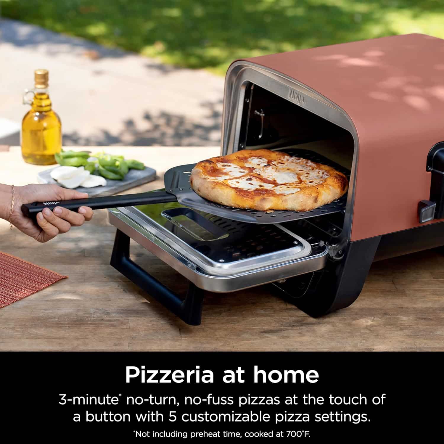 Oven3 Ninja Woodfire Outdoor Oven cooking artisan pizza on a backyard patio